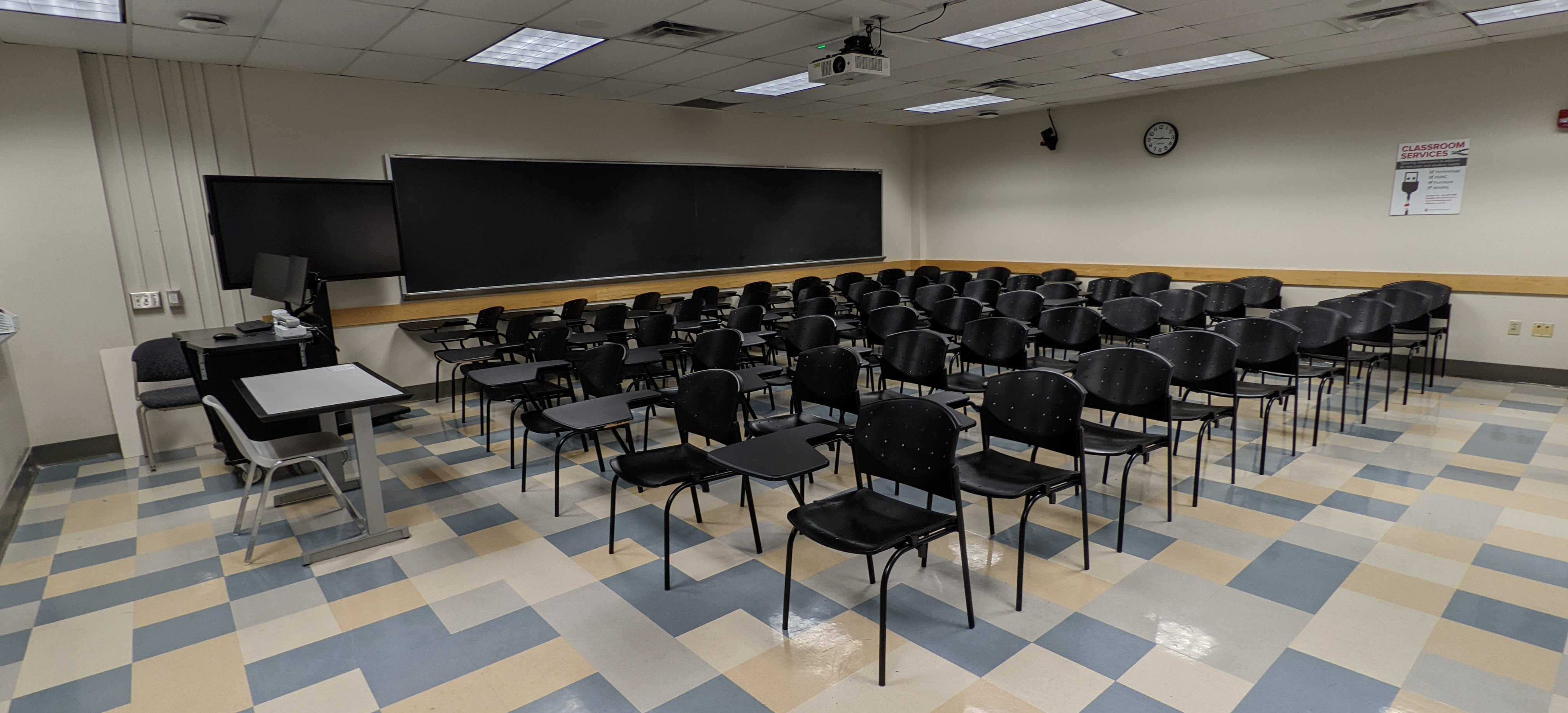 Journalism 239 before its renovation, featuring dated linoleum flooring and hard-to-reconfigure seating