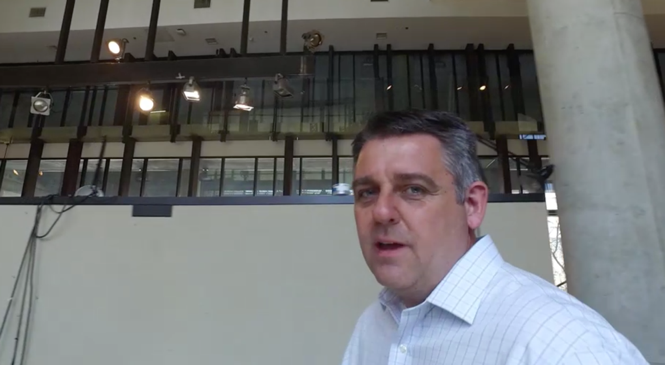 Michael Knemeyer, Associate Professor of Logistics, walking through a building talking to a camera.