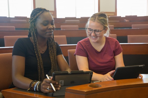 Two students looking at iPads and interacting