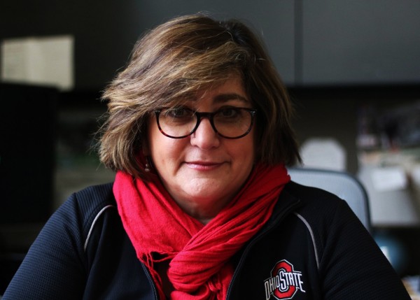 A photograph of Nicole Kraft, who is wearing a red scarf and a jacket with The Ohio State University logo.