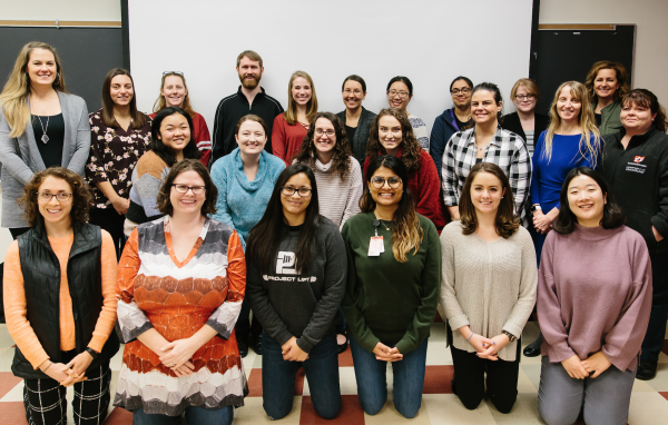 Twenty instructors huddle together for a group picture after completing training