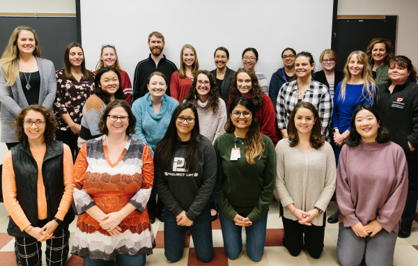 Twenty instructors huddle together for a group picture after completing training 