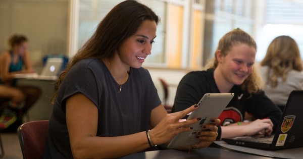 A student holding an iPad.