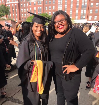 Ohio State alumna Tomitha Zimmerman, wearing graduation regalia, stands next to College of Social Work Outreach Program Coordinator Bryanna Stigger